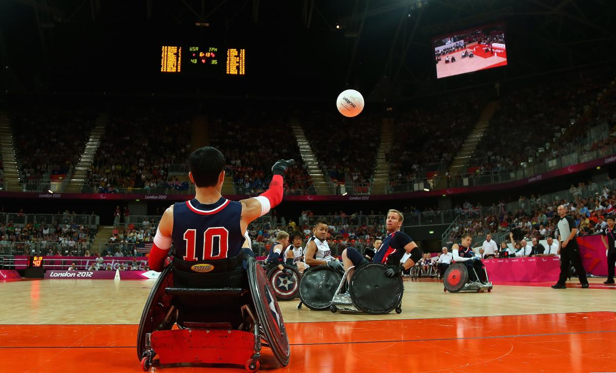 Andy Cohn of the United States Man in wheelchair throwing a ball, two other men trying to catch it