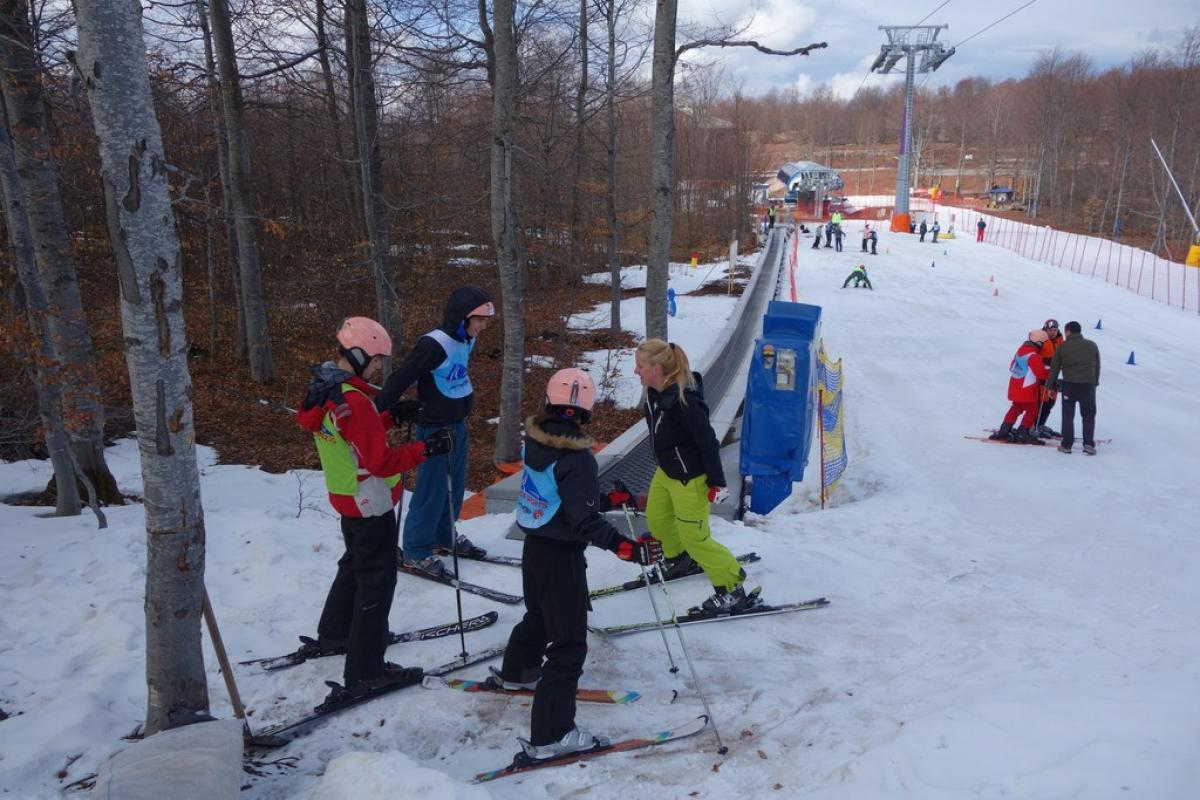 A group of youngsters are taught how to ski