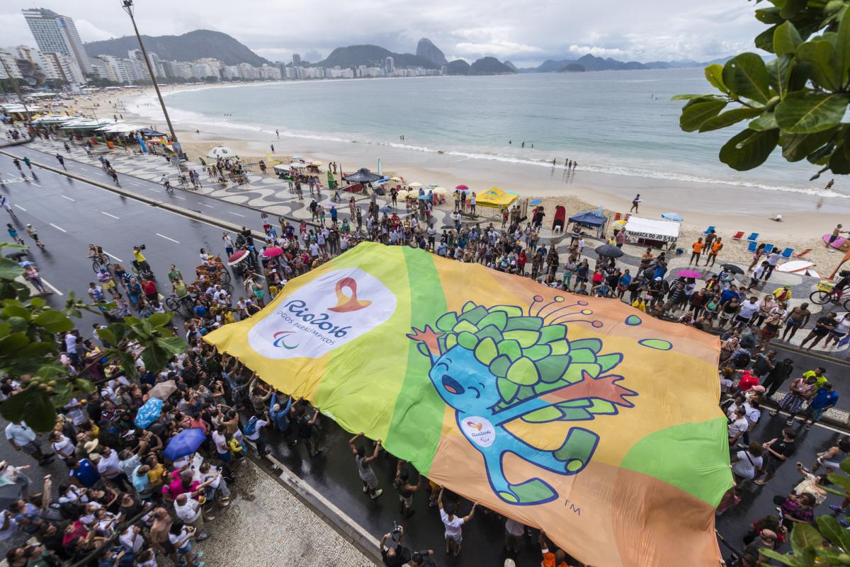 Crowd of people from above, holding a huge banner with Rio motives