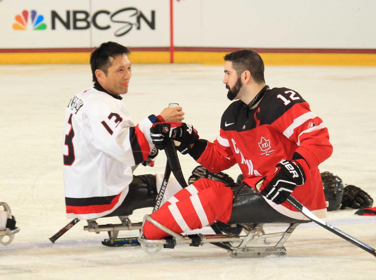 Canada's Greg Westlake, right, shakes hands with Japan's Mamoru Yoshikawa after their preliminary round game at Buffalo 2015.