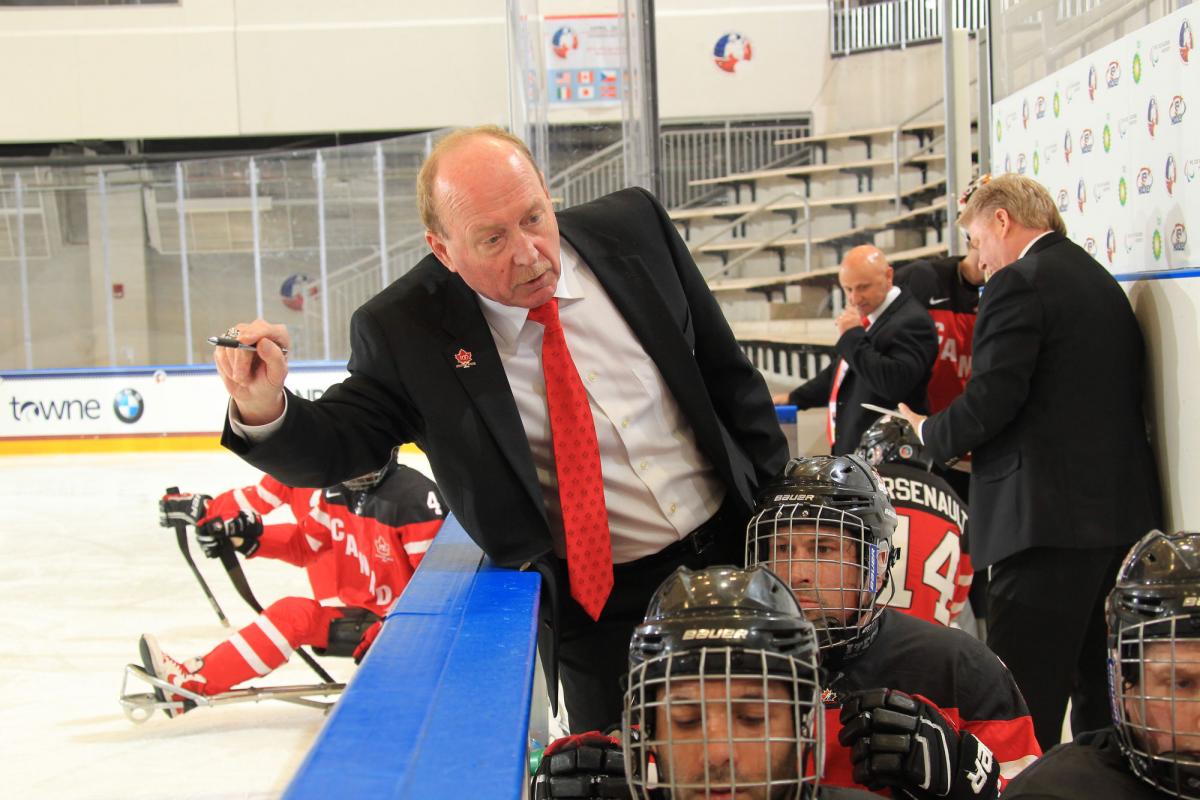 Ice sledge hockey coach talking to his players.