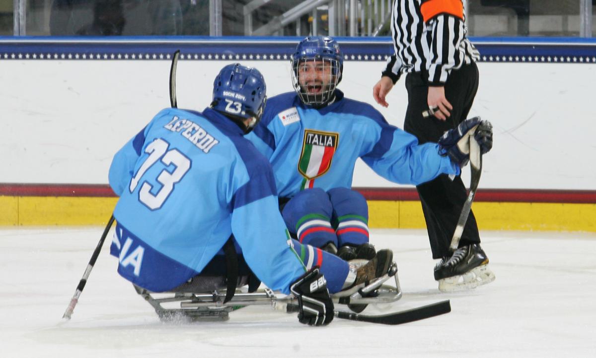 Two sledge hockey players in blue jerseys on the ice