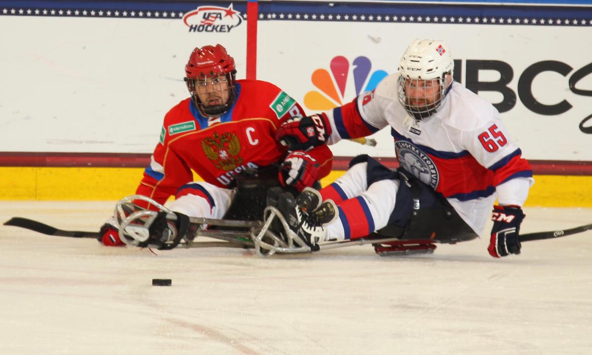 Thomas Jacobsen - Russia v Norway - 2015 IPC Ice Sledge Hockey World Championships A-Pool Two ice sledge hockey players chasing after the puck.