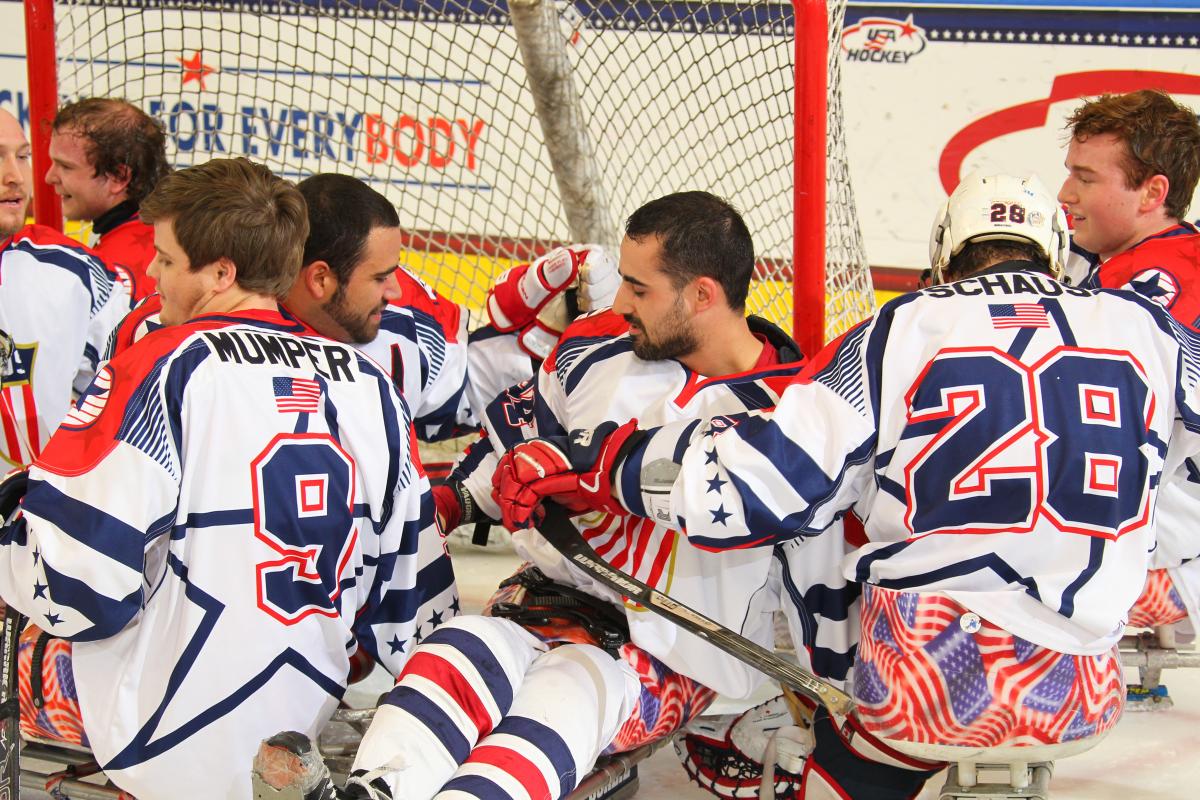 Group of sledge hockey players celebrating on the ice