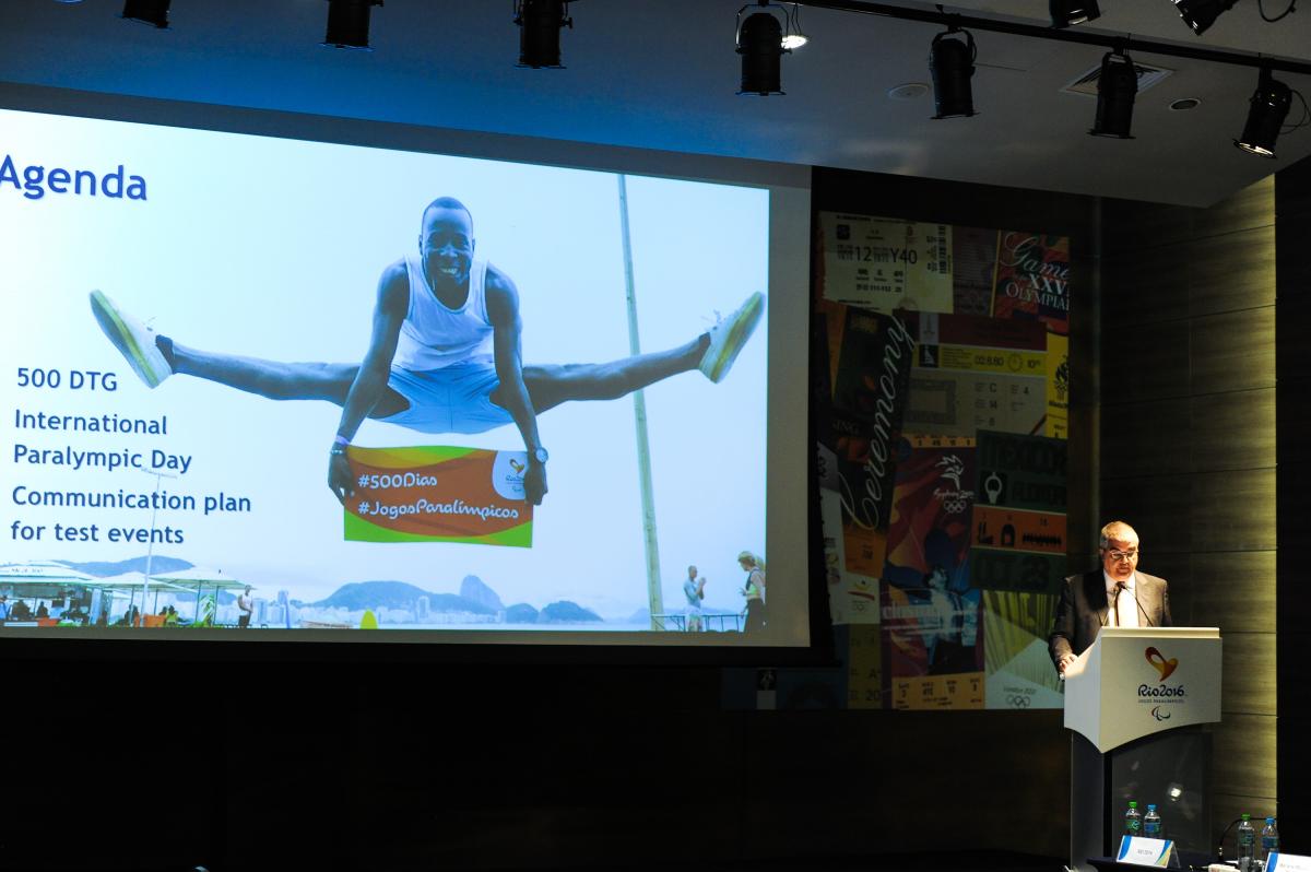 Rio 2016 Project Review Man on podium, speaking to an audience