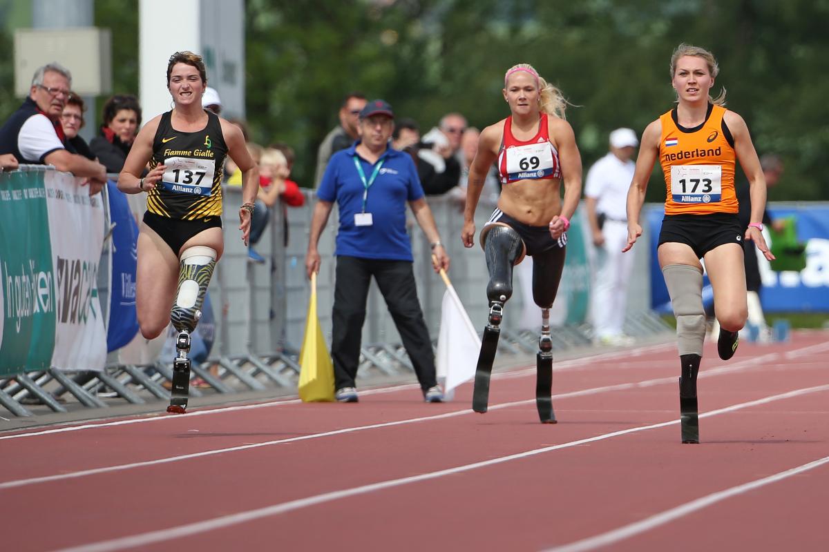 A group of female blade runners sprinting down the 100m straight.