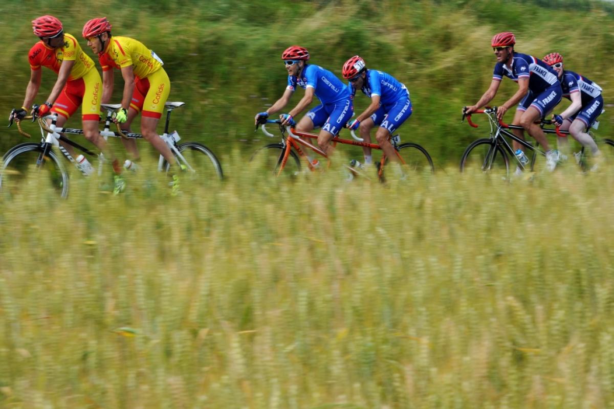 Three tandems with six cyclists surrounded by nature