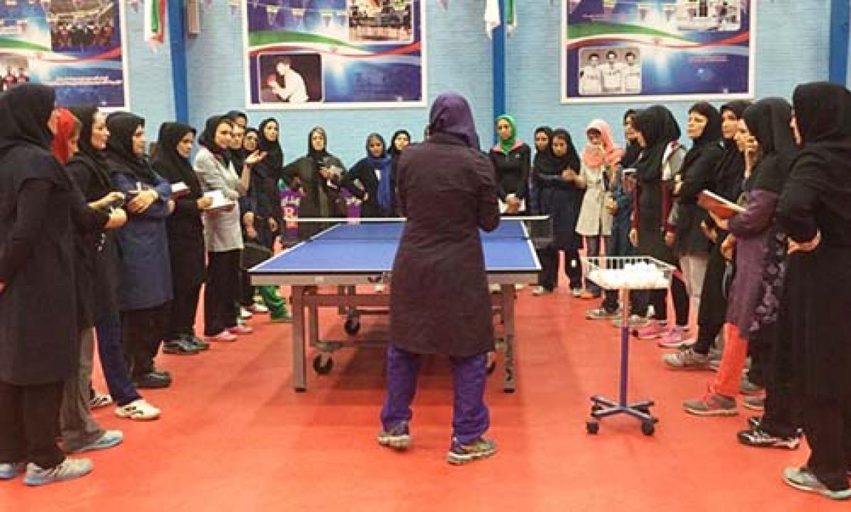 Group of women grouped around a table tennis table