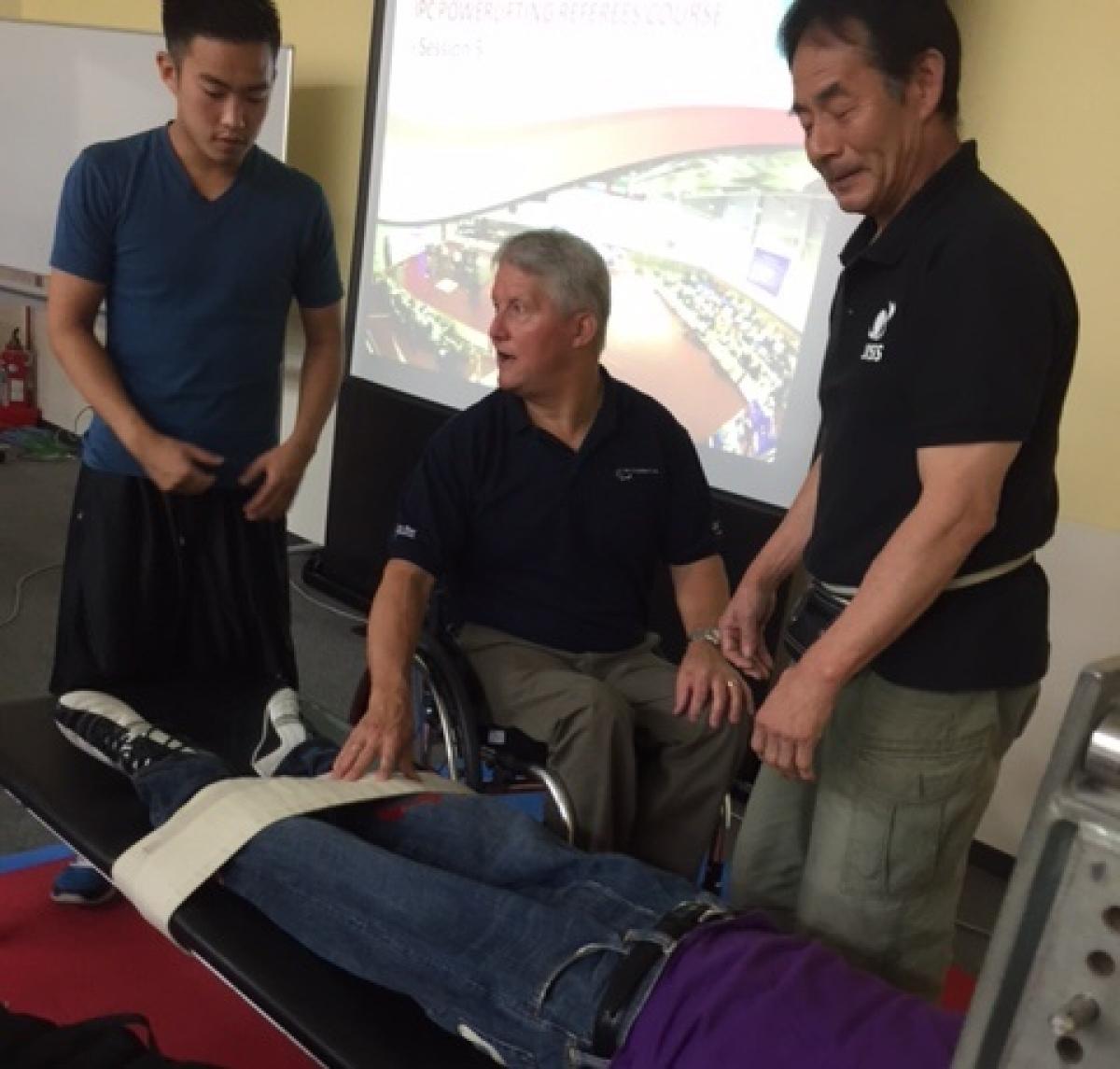 Japan powerlifting referee training Man in wheelchair explains to audience