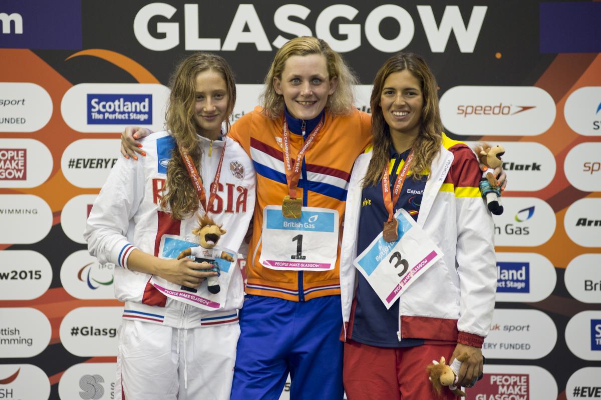 Three swimmers pose with their medals