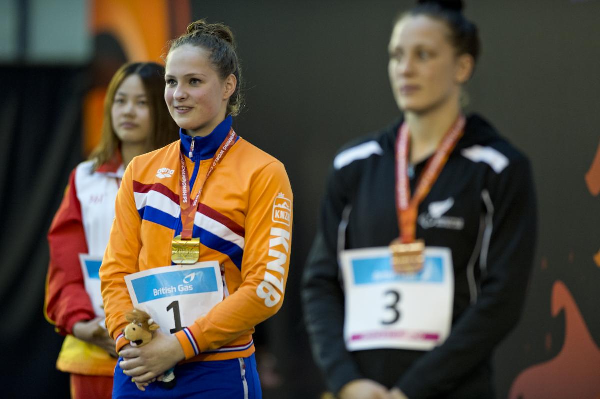Three women in training suits on a podium
