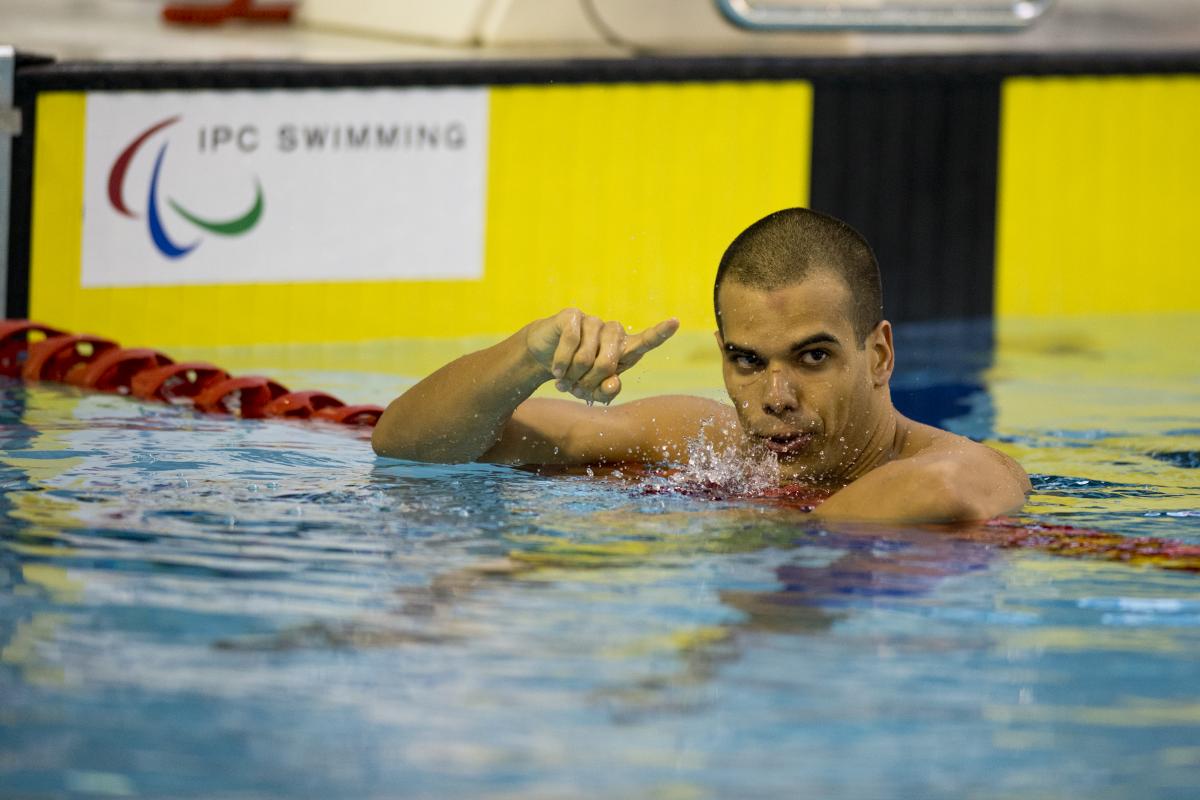 A swimmer stays in the water after finishing a race.