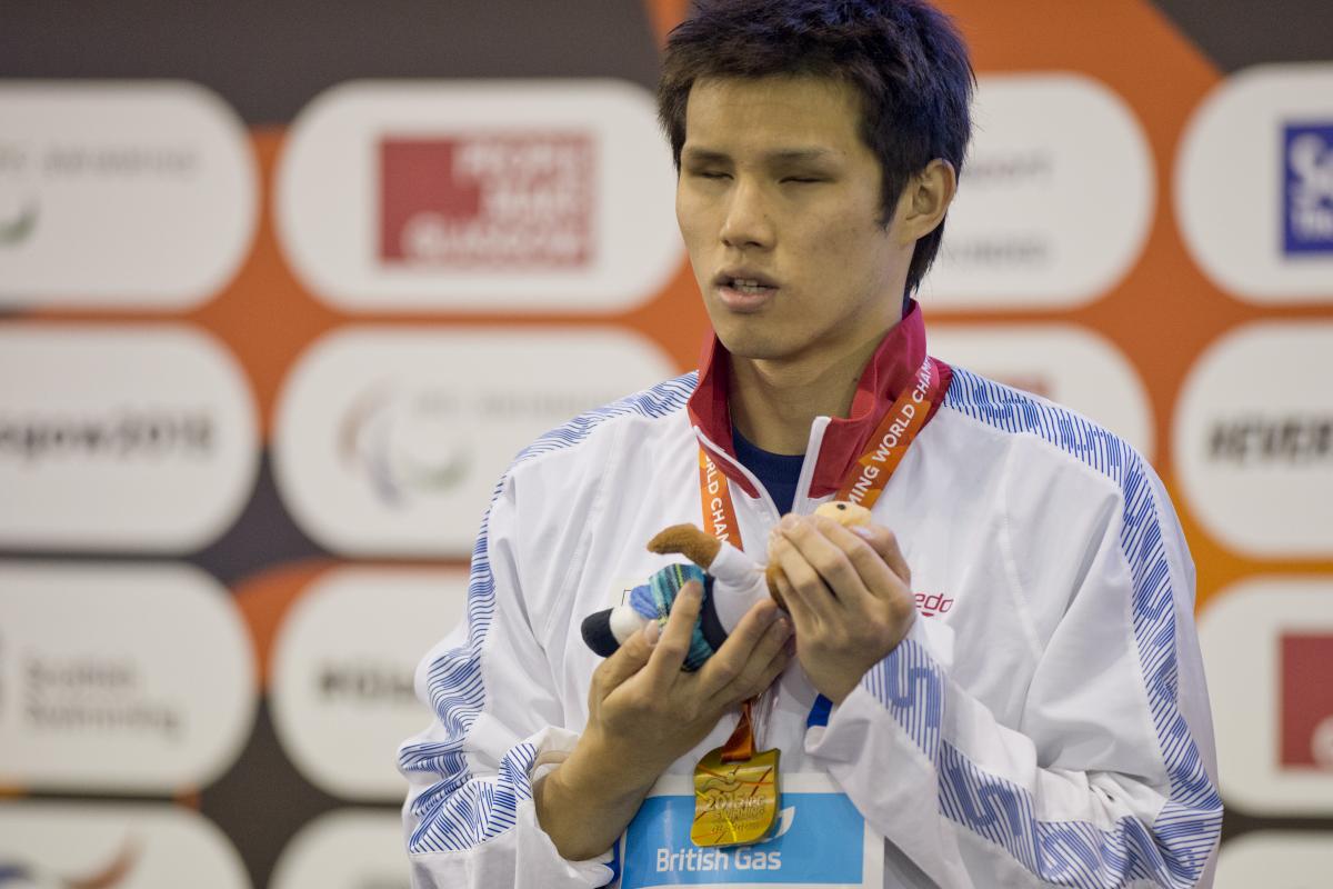 Man with a medal around his neck on a podium