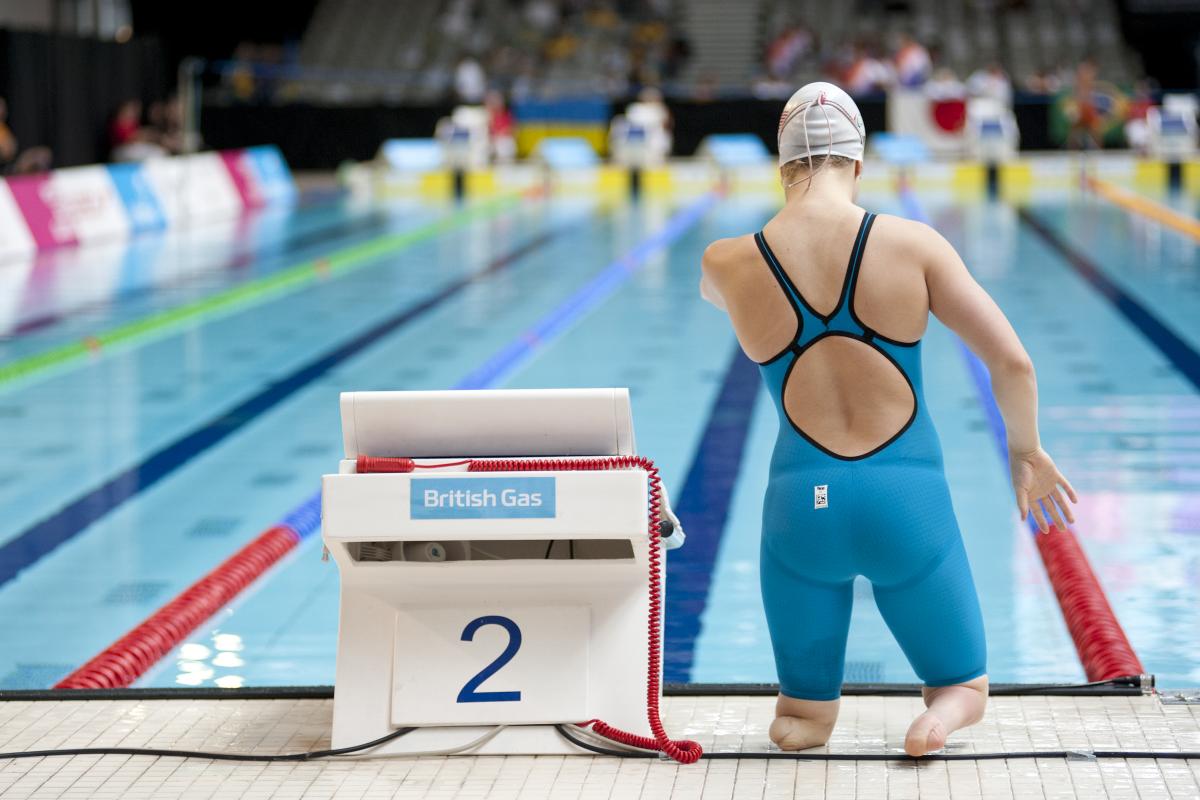 Backside of a woman with no lower legs at a swimming pool