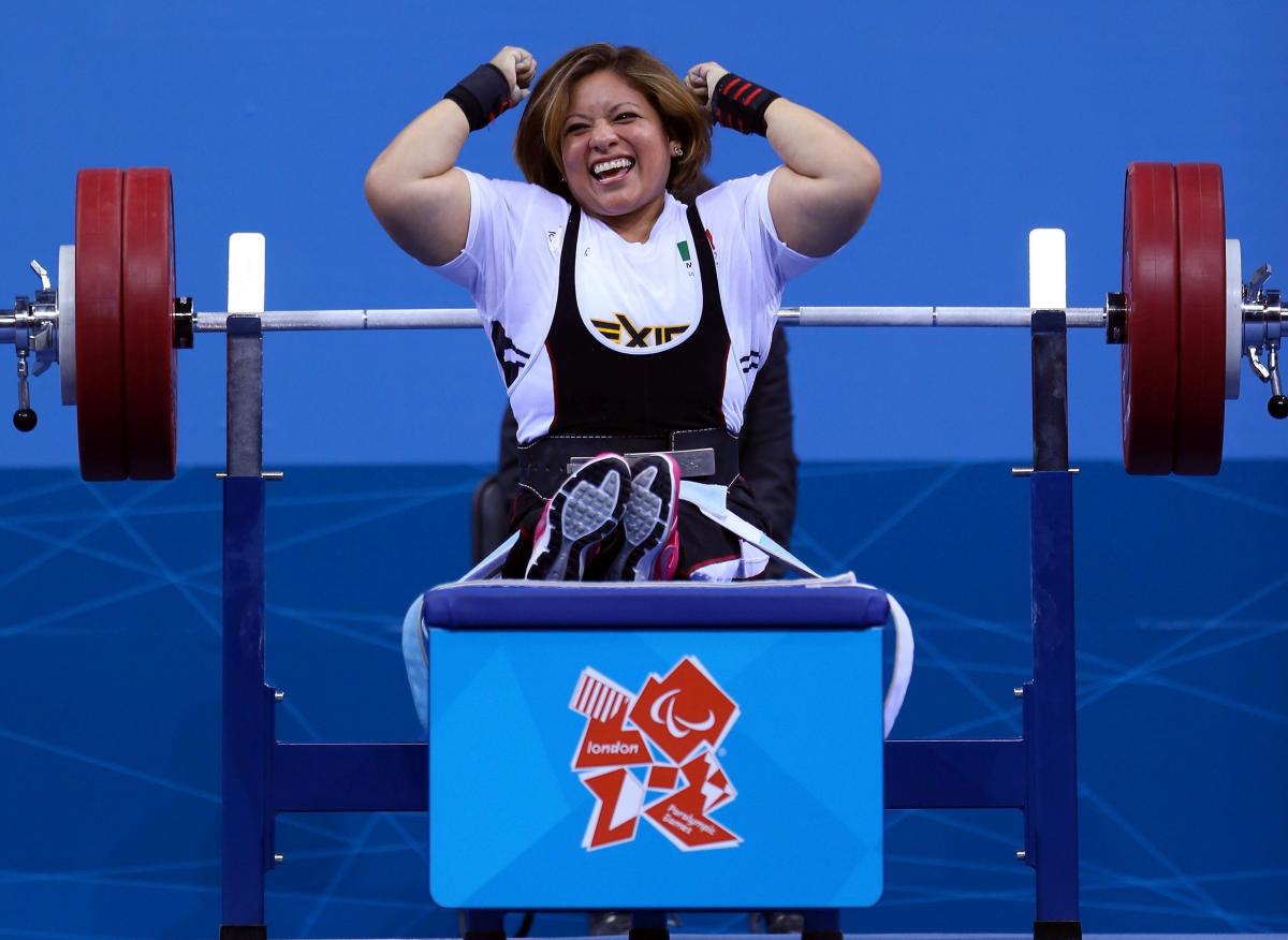 A picture of a powerlifter on a bench celebrating