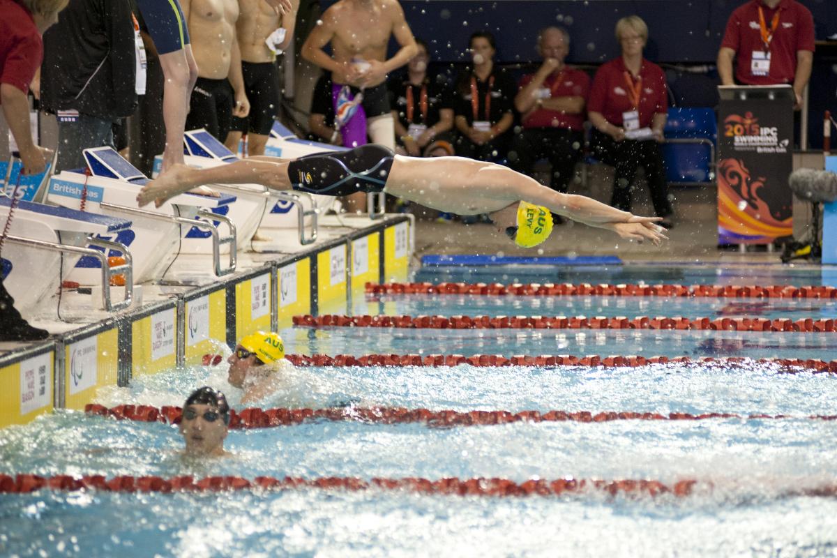 View on the starting zone in a swimming pool, one athlete jumping in the water