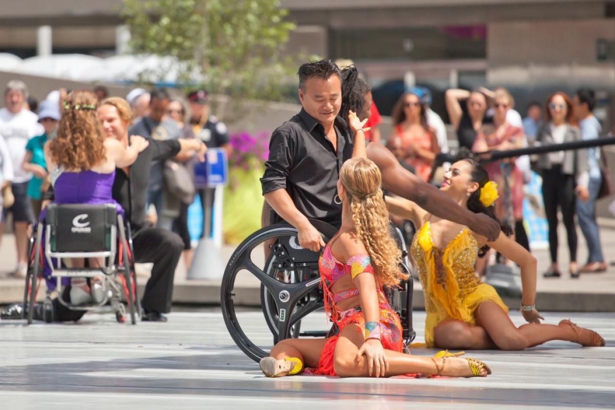 Group of dancers (wheelchairs and standing) on a stage performing