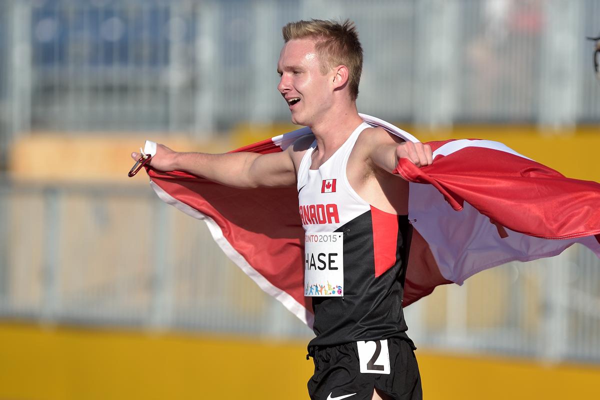 Mitchell Chase walks wrapped in the Canadian flag