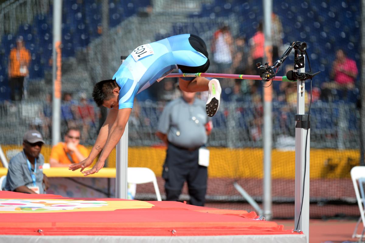 Man during a high jump in a stadium