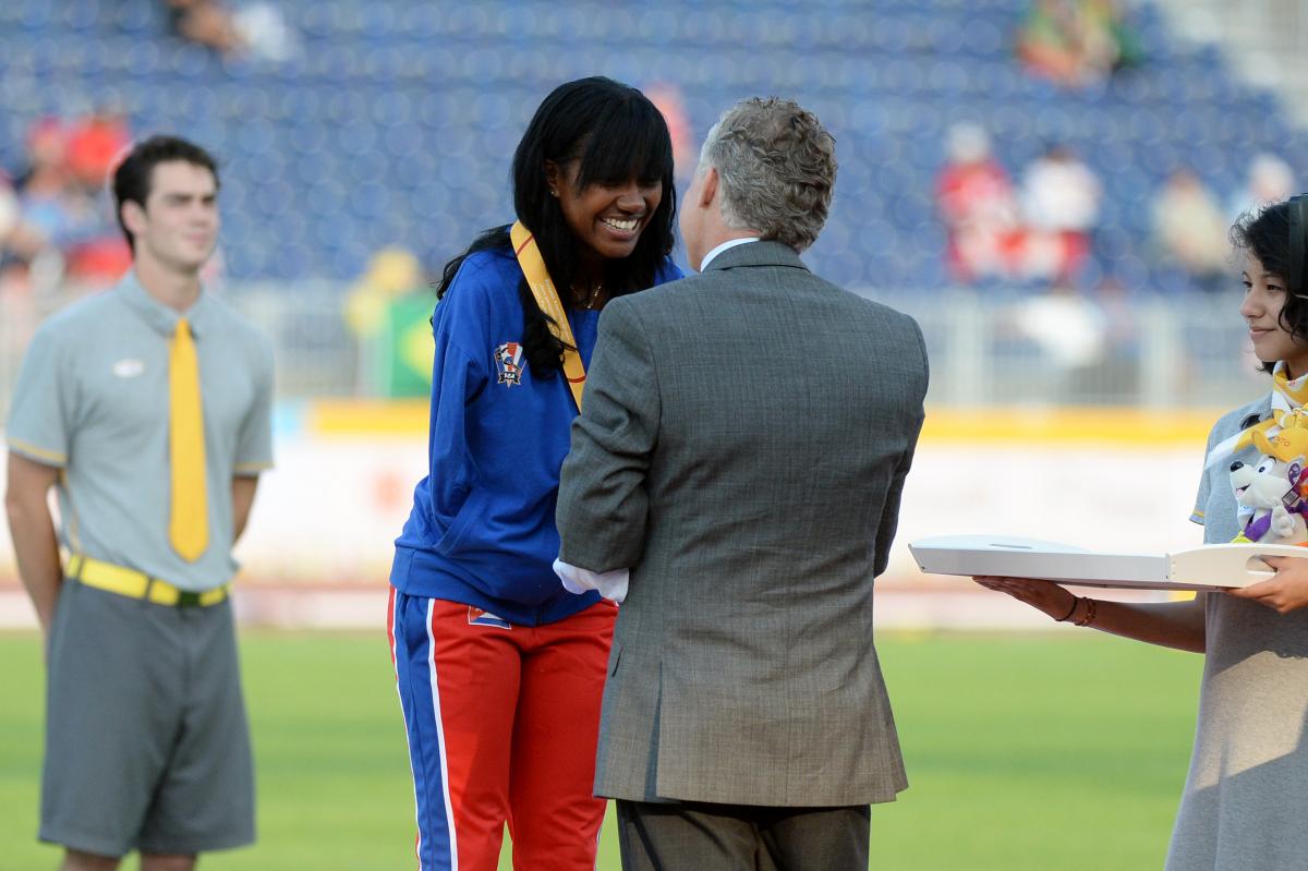 Yunidis Castillo receives her gold medal for the women's 200m T47, handed over by Patrick Jarvis.