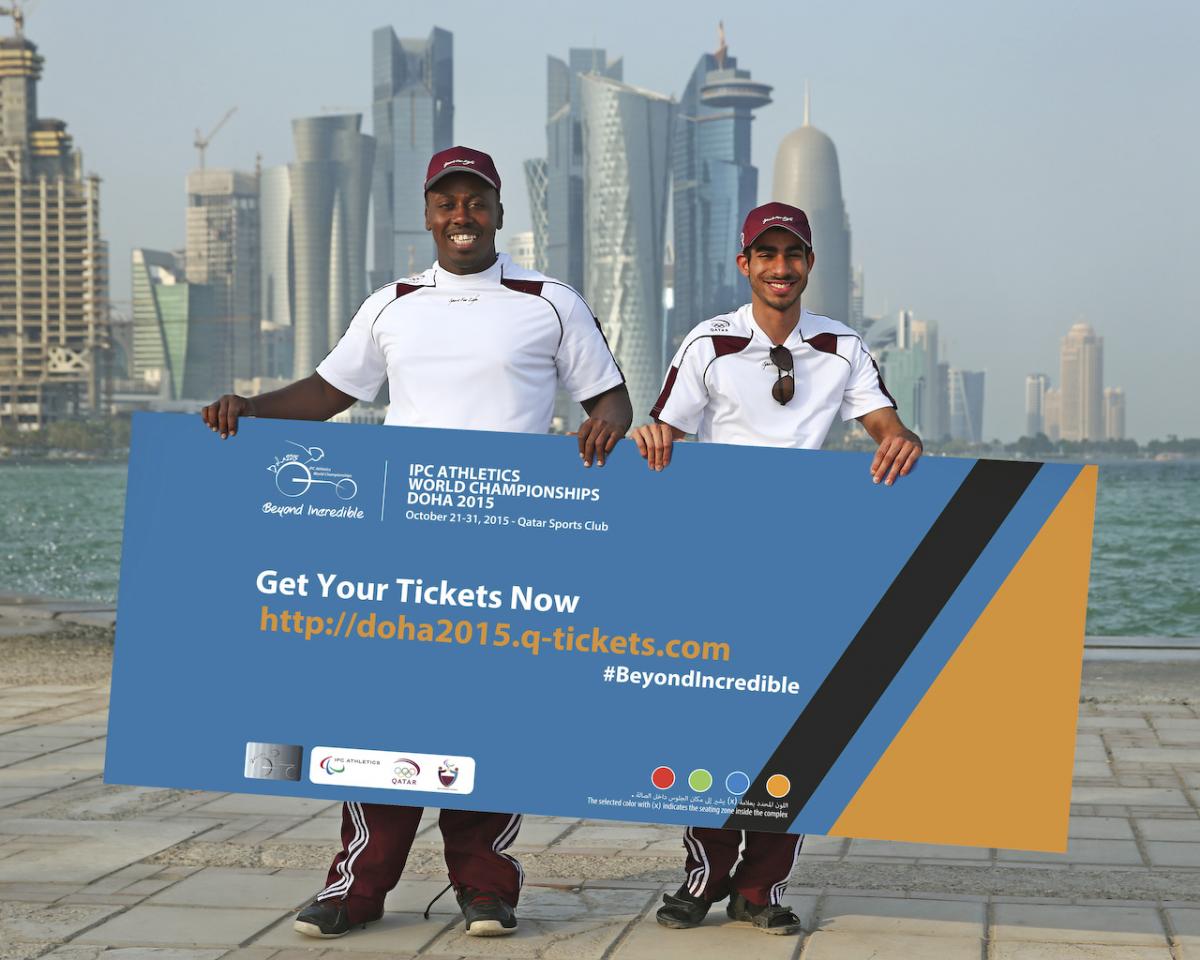 Two men holding a banner in front of a modern skyline