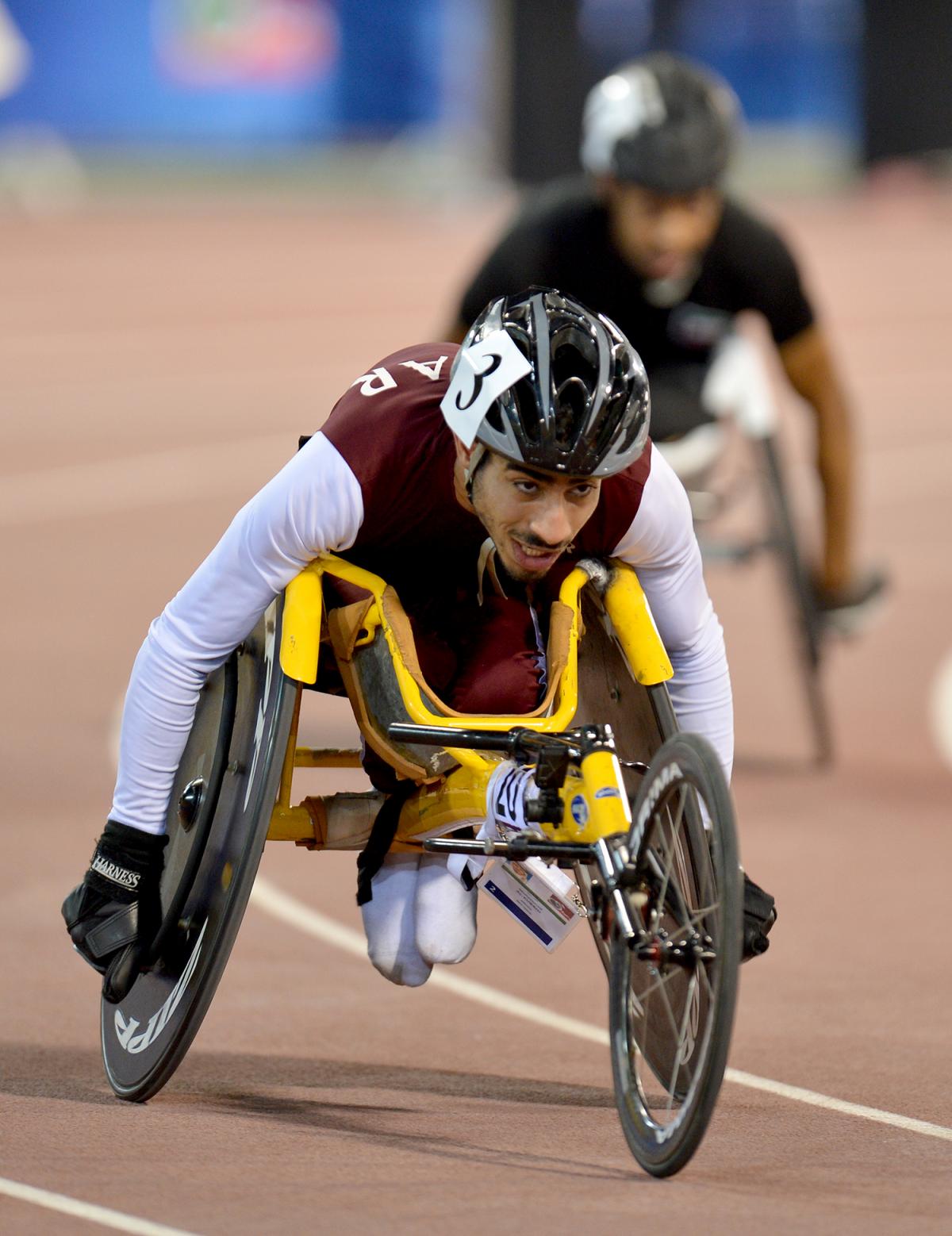 Man in racing wheelchair on track