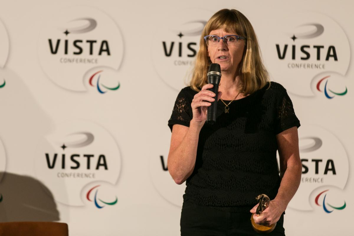 Woman on a stage, giving a speech