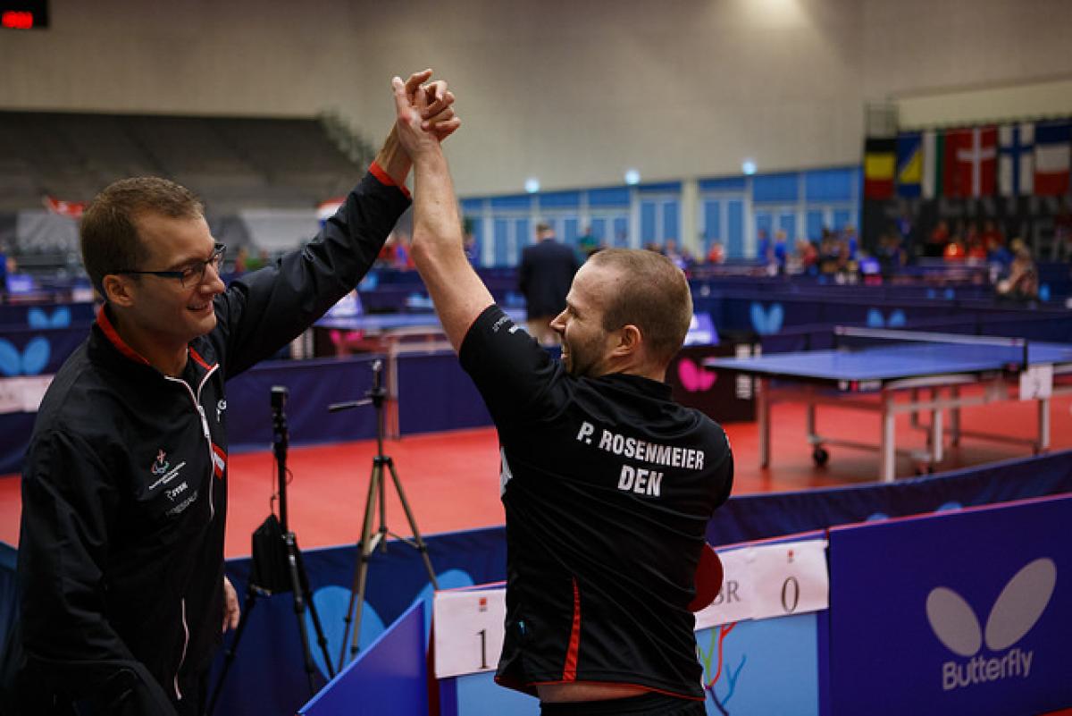 Two table tennis players celebrate.