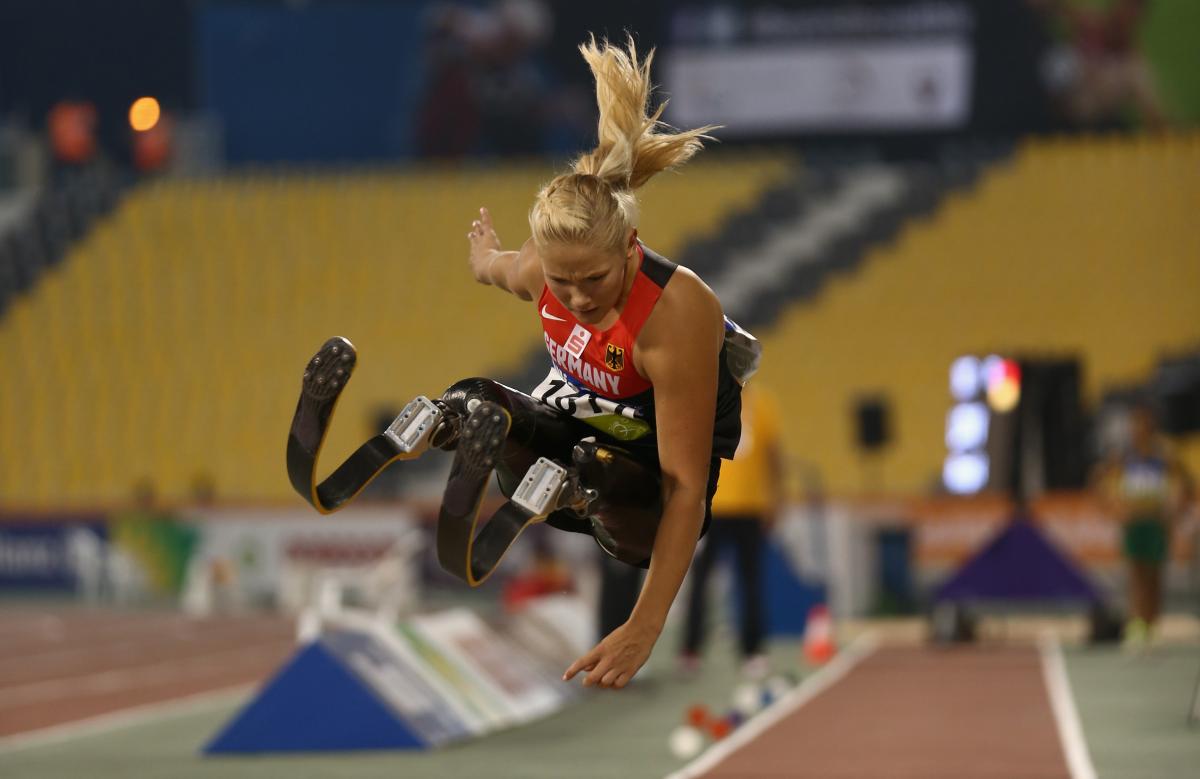 Double leg amputee woman doing long jump