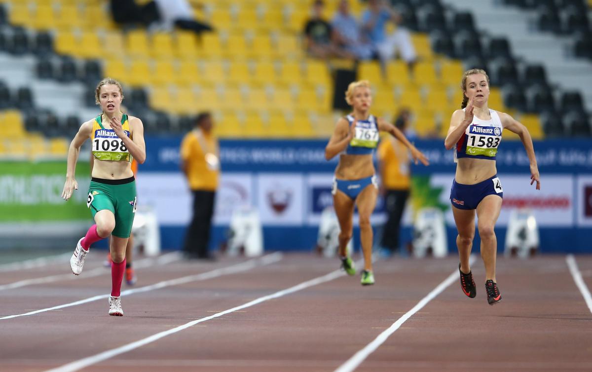 Two young women running on a track, head to head
