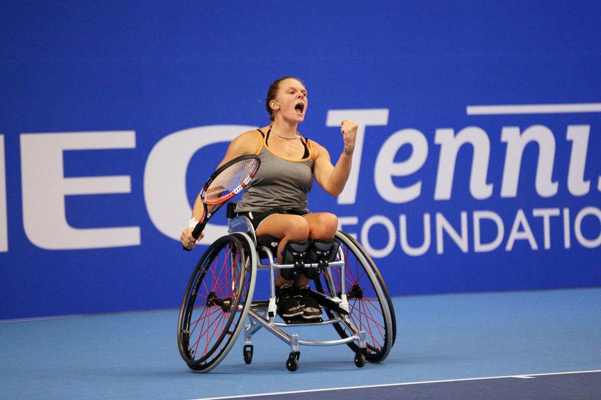 Woman in wheelchair celebrates after wheelchair tennis point