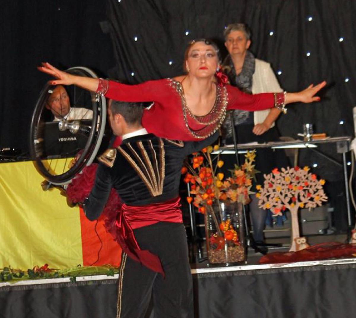 A wheelchair dancer is held aloft during a dance 