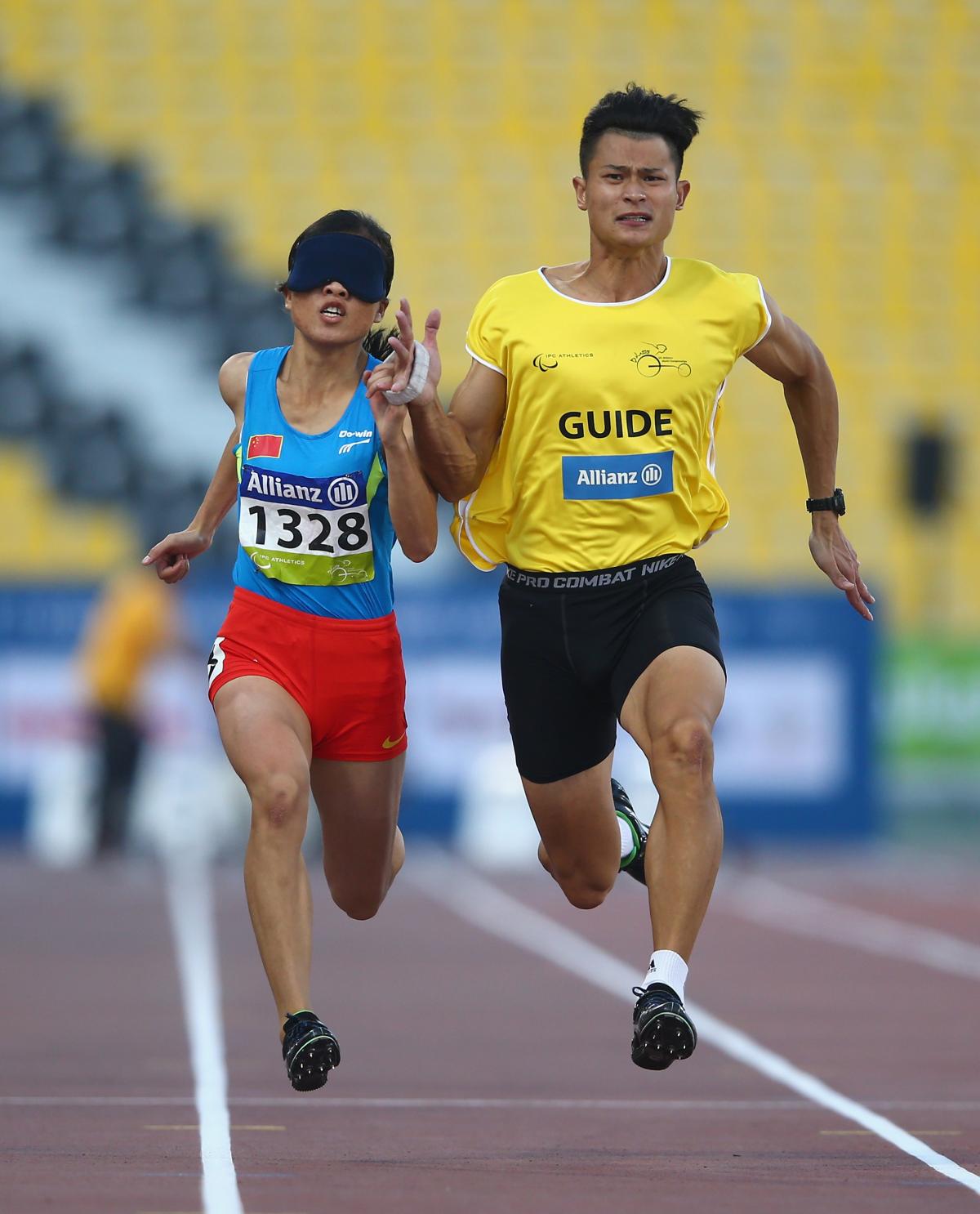 Blindefolded woman runs with guide