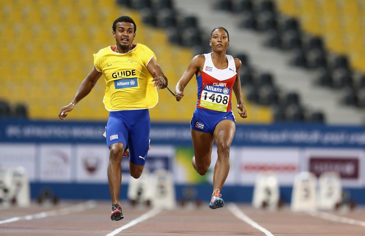 Woman and man sprinting on a track side by side