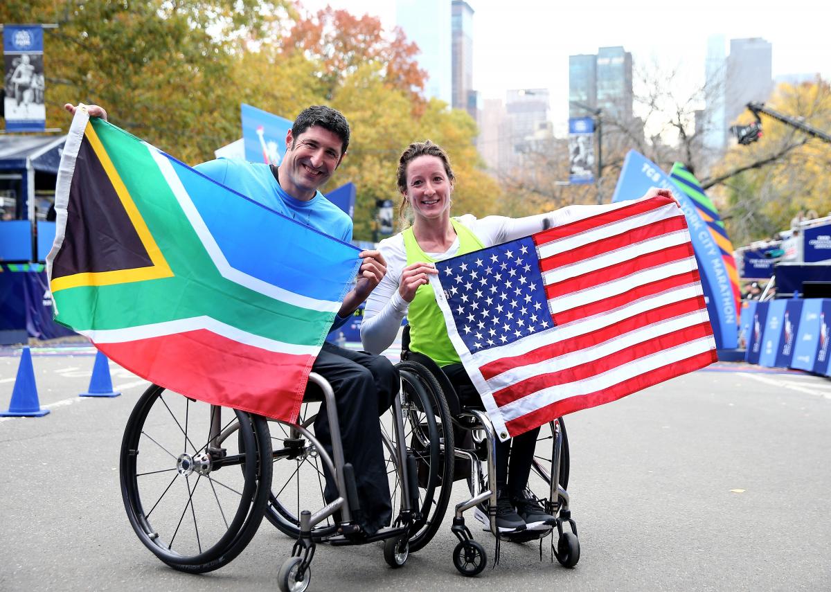 Tatyanna McFadden and Ernst Van Dyk - New York City Marathon Man and woman in wheelchair hold their countries' respective flags.
