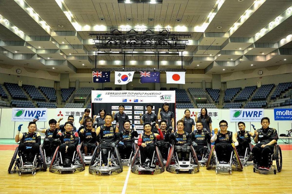 A team of wheelchair rugby players pose for a photo.