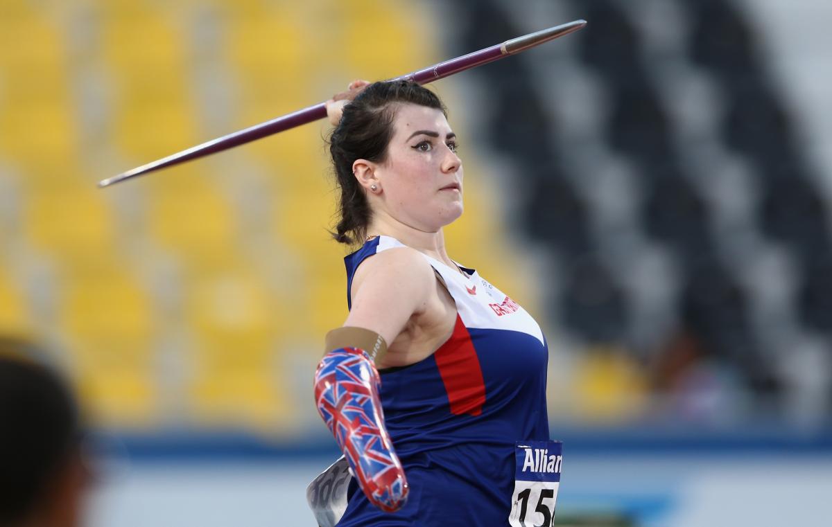 Woman with arm prosthesis throwing a javelin