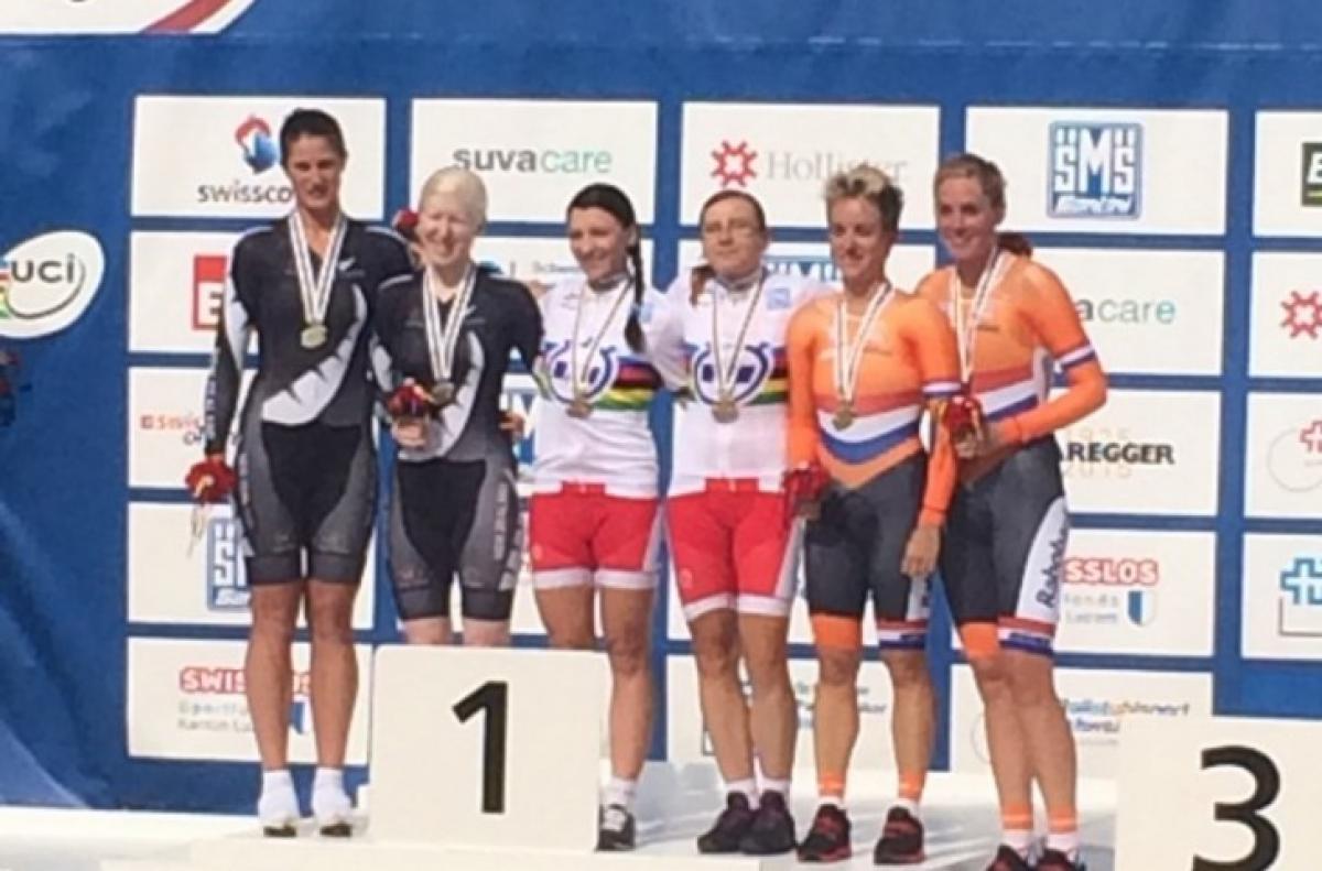 Six female cyclists on a podium