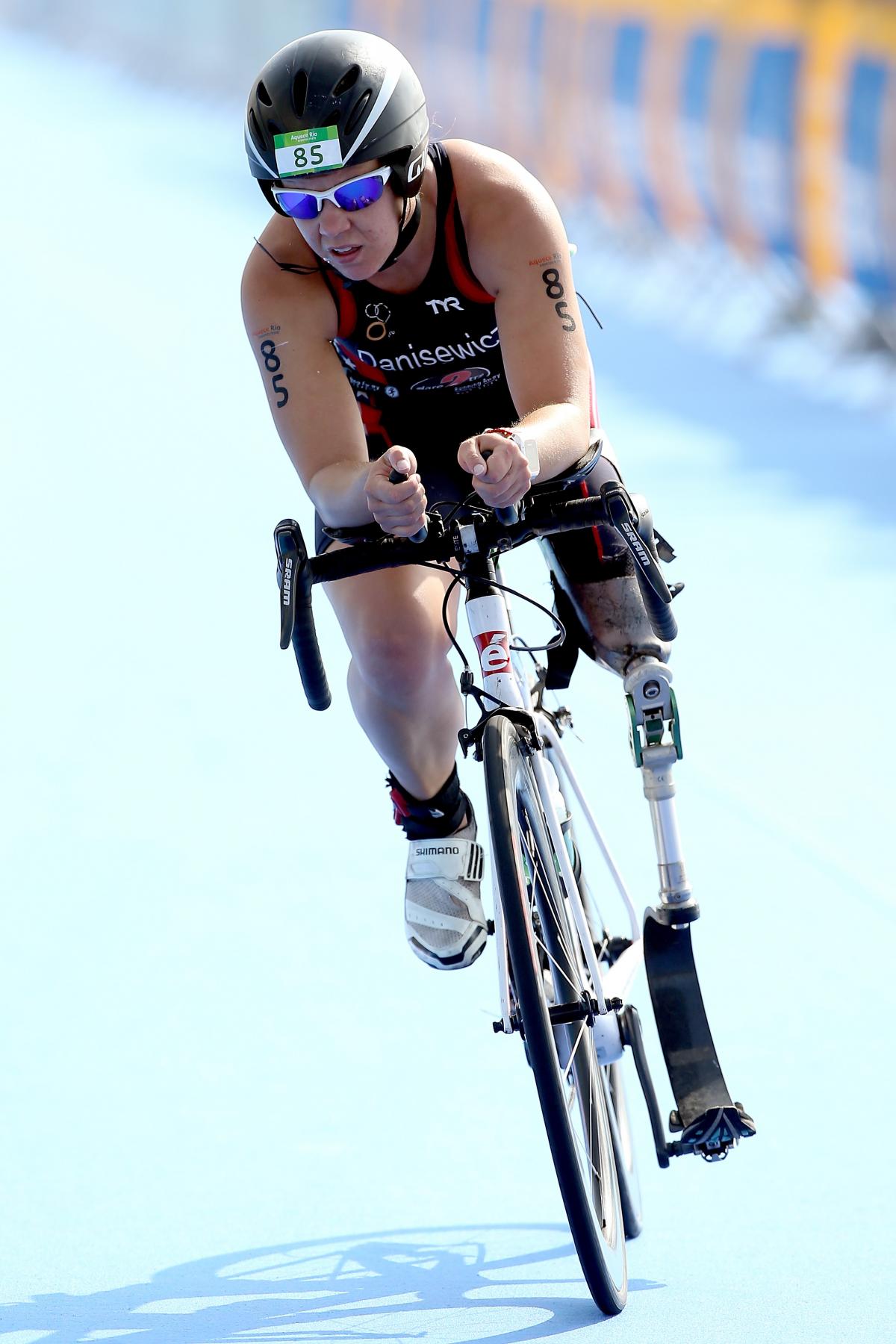 Hailey Danisewicz a female in black clothing and a black helmet riding a bicycle