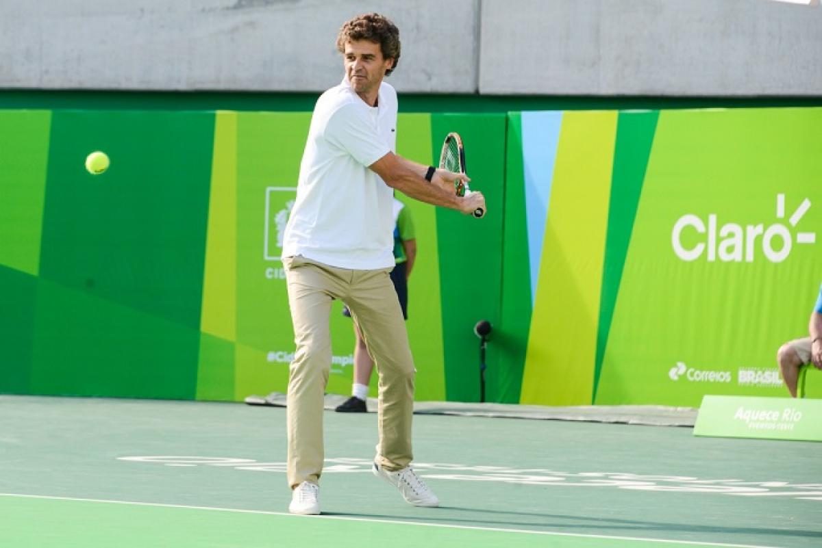 Gustavo Kuerten Man holding tennis raquet about to hit the ball