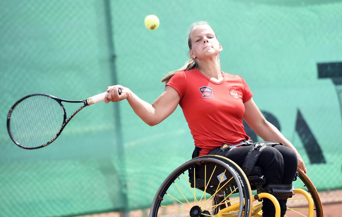 Viktoriia Lvova - wheelchair tennis Girl in wheelchair hits a forehand return.