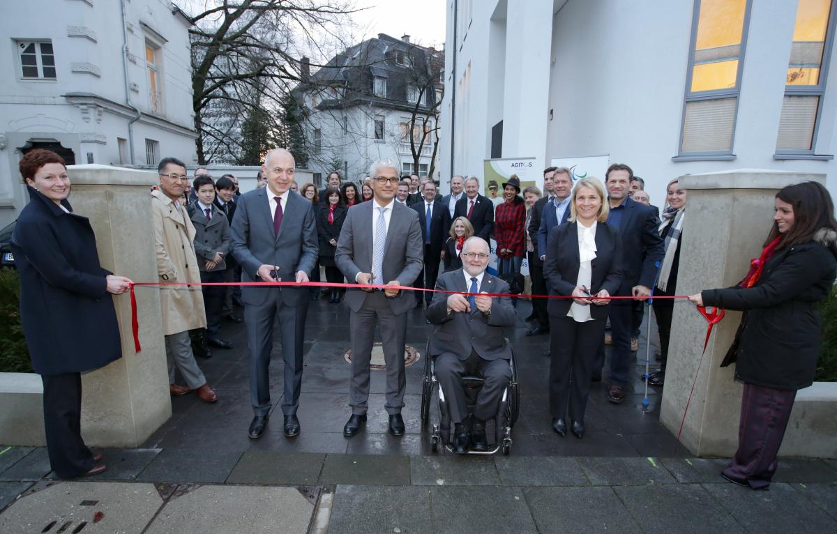 Opening new IPC building Picture of four people cutting a red ribbon to open a new building.