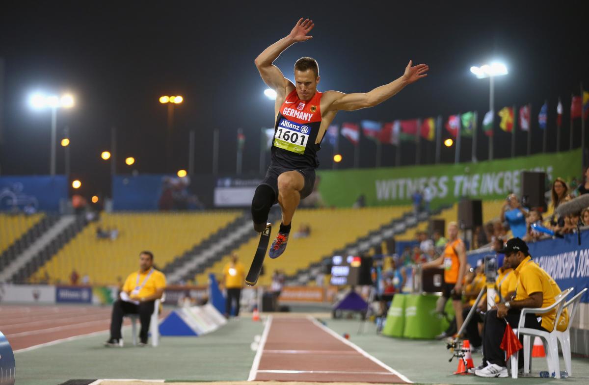 a male from Germany wearing red and black clothes competing in the long jump