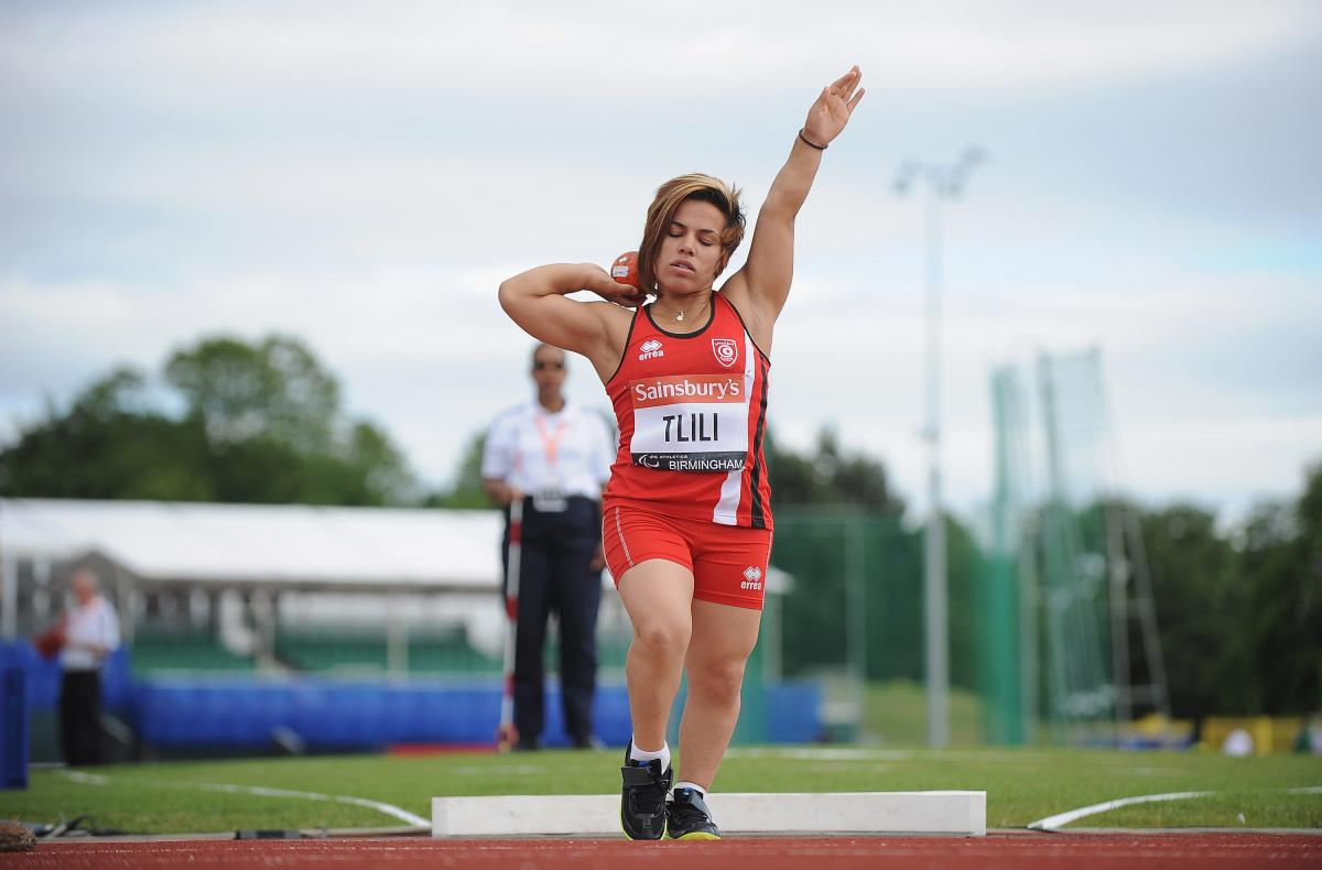 Raoua Tlili a female from Tunisia wearing red and competing in the shot put