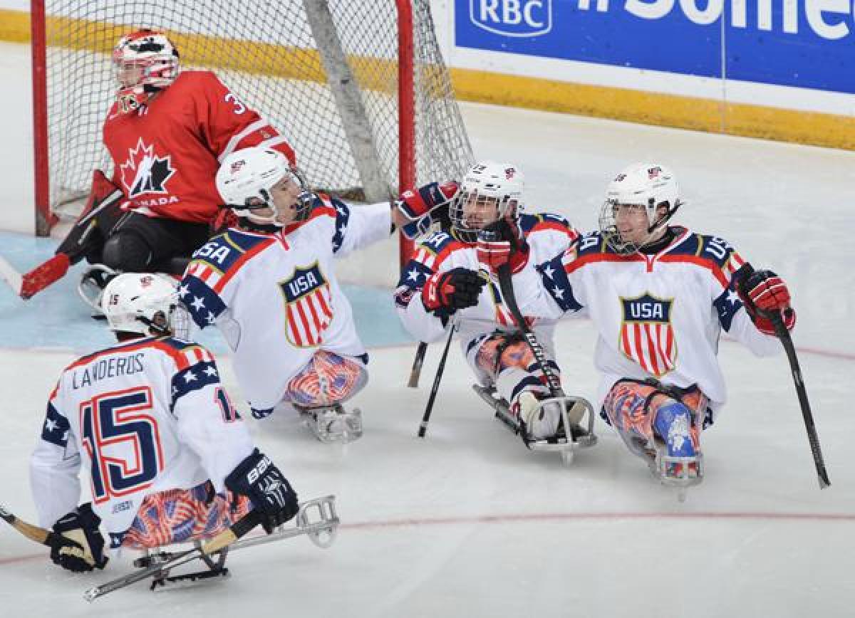 US ice sledge hockey players celebrate after a goal