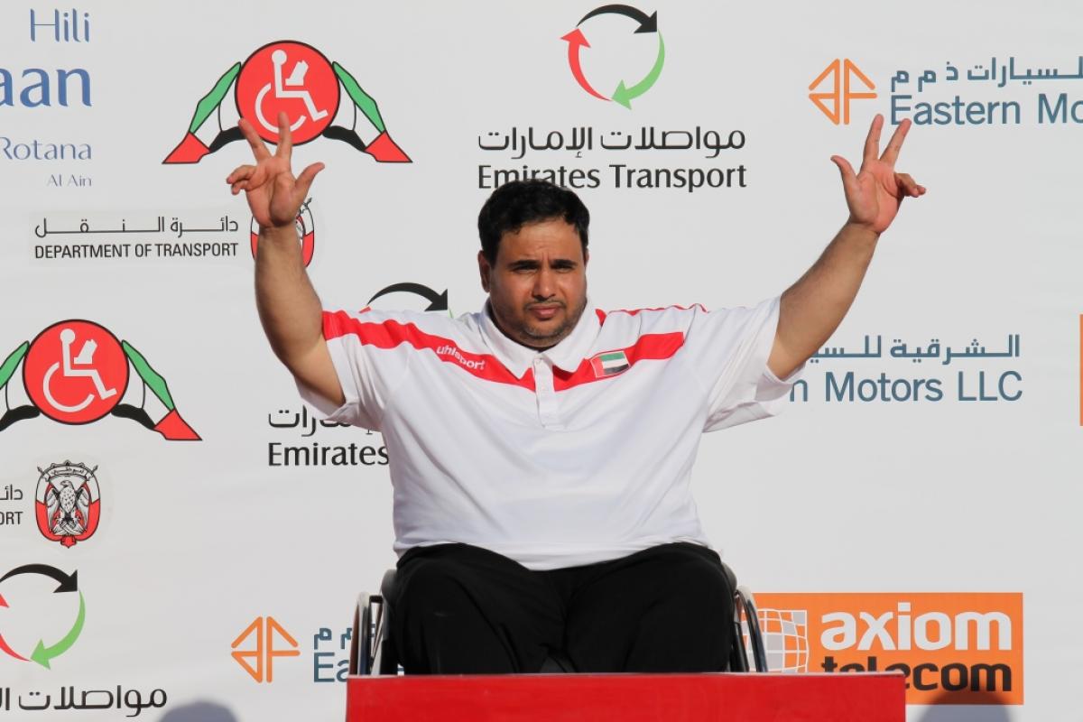 Man in wheelchair on a podium, celebrating