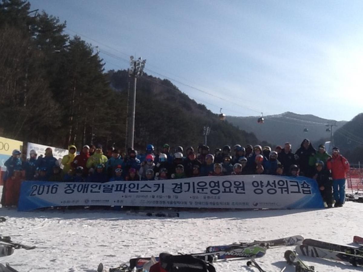 Group shot of people in the snow holding a banner