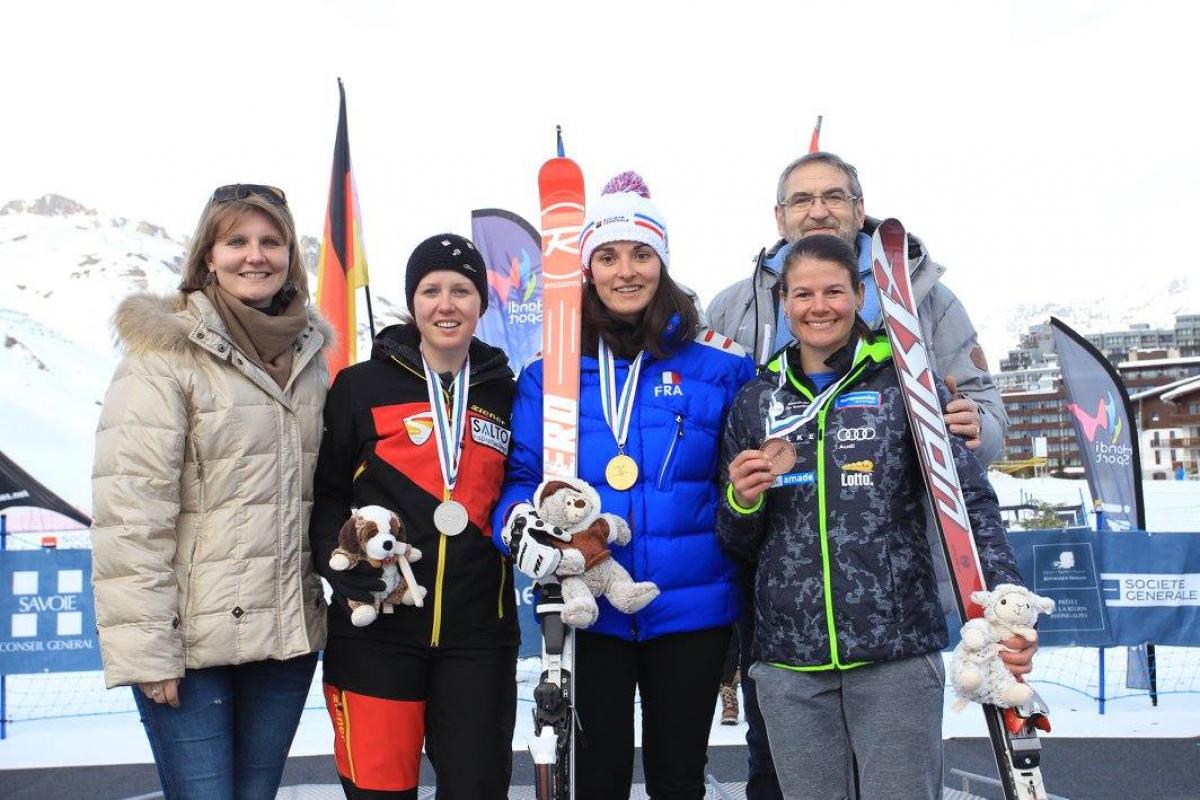 Three women alpine skiers pose with their medals from a World Cup