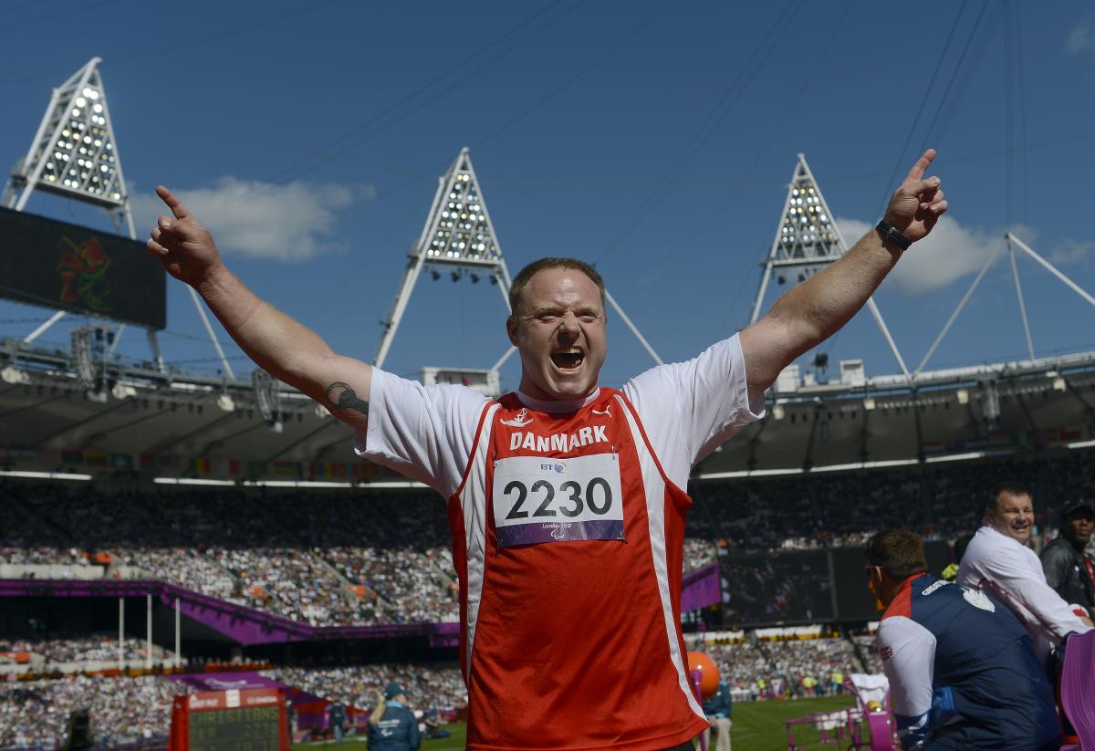 Man in stadium waves his arms in the air, celebrates