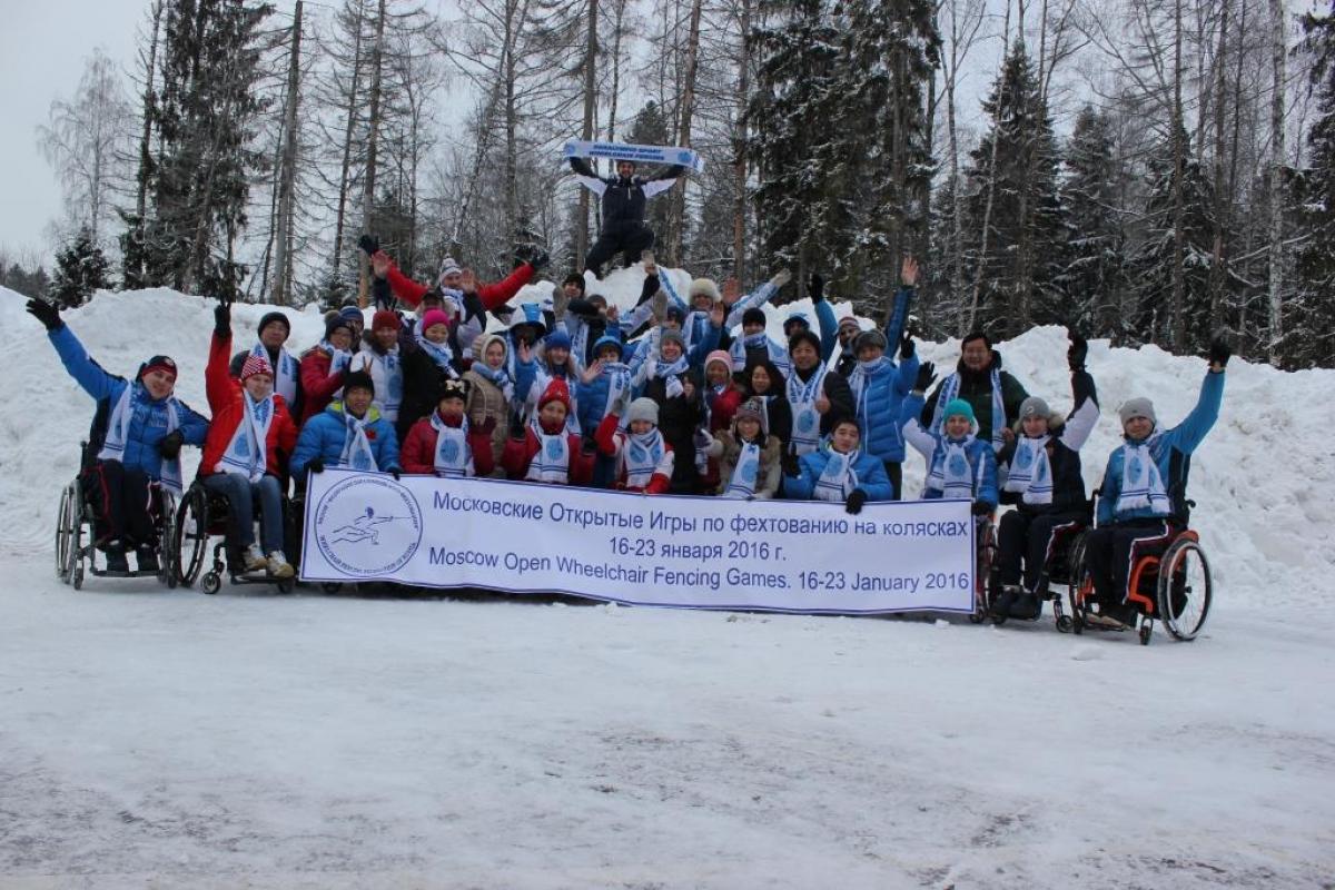 Group picture of people in wheelchairs and standing people in the snow
